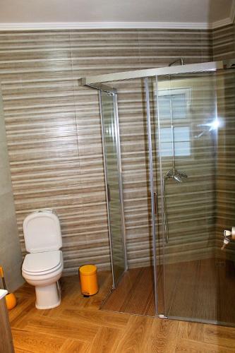 a bathroom with a toilet and a glass shower at Casa Pôr do Sol in Ginetes