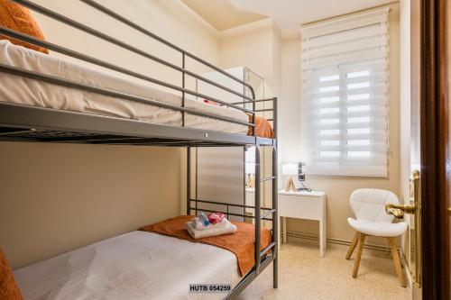 a bedroom with two bunk beds and a chair at Alcam Sant Adria in Sant Adria de Besos