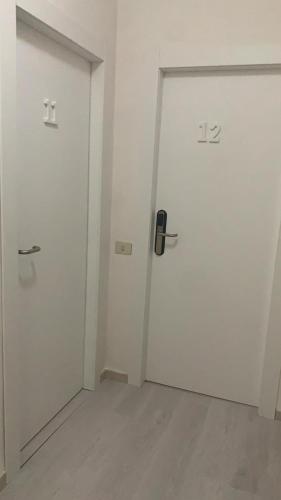 an empty room with two white doors in it at Hotel Due Pini Conte in Angri