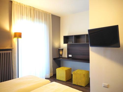 a bedroom with a bed and a tv on a wall at Feldgärtenhof in Silandro