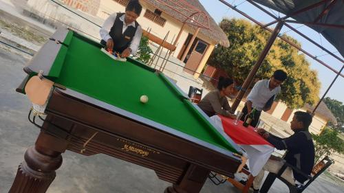 Un groupe de personnes autour d'un billard dans l'établissement Elephant Garden Hotel and Resort Pvt Ltd, à Kanchanpur