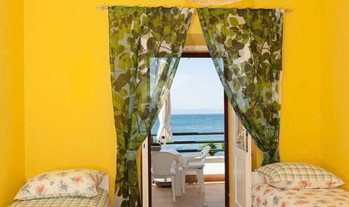 een slaapkamer met een raam met uitzicht op de oceaan bij BEACH APARTMENT in Podgora