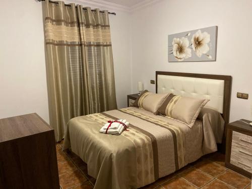 1 dormitorio con 1 cama grande con un cuadro de flores en la pared en Vivienda Rural Los Tajos de Setenil, en Setenil