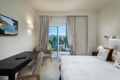 une chambre d'hôtel avec un bureau et une chambre avec un lit et une salle de bains privative. dans l'établissement Hotel Villa Margherita, à Golfo Aranci