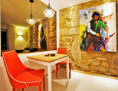 a room with a table and a painting on the wall at Almar Apartments in Póvoa de Varzim