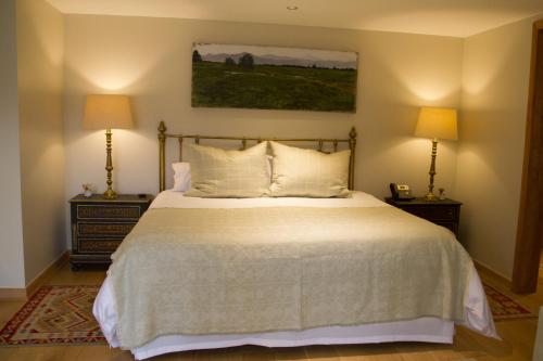 a bedroom with a large bed with two lamps at Leonera Hotel in La Leonera