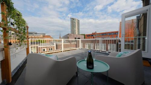 a balcony with a bottle of wine on a table at Sunny 45m2 Penthouse with Balcony and Terrace - R65C in Eindhoven