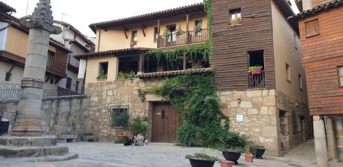 a building with ivy growing on the side of it at Casa Rural La Picota in Valverde de la Vera