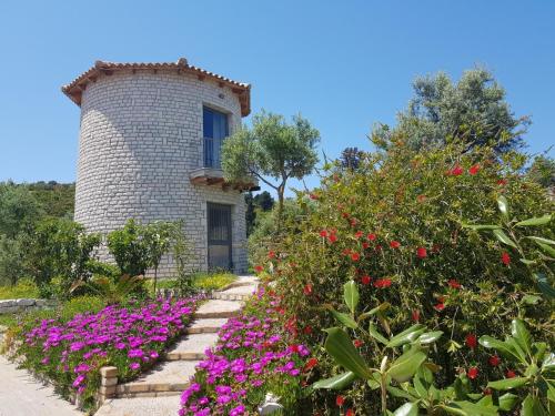 a garden with flowers in front of a building at Villas Panorama Apolpaina Lefkas in Apolpaina