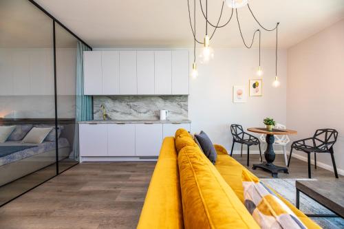 a living room with a couch and a kitchen at Modern spacious studio w/ Sea Views in Klaipėda
