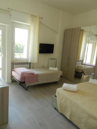 a hotel room with two beds and a flat screen tv at Appartamenti Via Cortonese 1 in Perugia