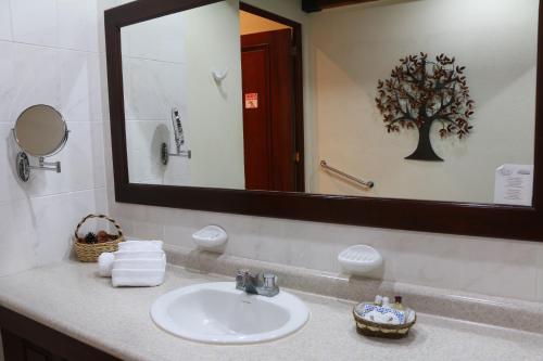 a bathroom with a sink and a mirror at Hotel Pensión Bonifaz in Quetzaltenango