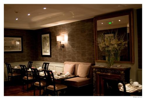 a dining room with a table and chairs and a fireplace at Hotel De La Treille in Lille