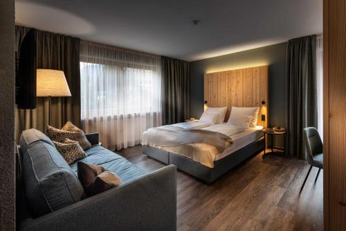 カンポ・トゥーレスにあるPension Moarhofのベッドとソファ付きのホテルルーム