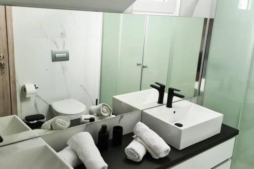 a bathroom with a sink and a toilet and a mirror at Villa Marmari 3 in Marmari