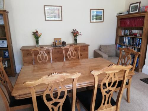a dining room with a wooden table and chairs at Lovaton Farmhouse in Okehampton