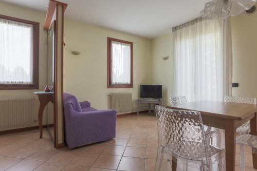 a living room with a table and chairs and a tv at Hotel Ristorante al Gabbiano in Ponte di Piave