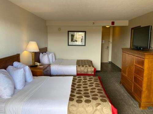 a hotel room with two beds and a flat screen tv at Ramada by Wyndham Albuquerque Midtown in Albuquerque