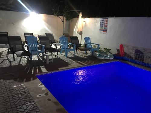 a swimming pool at night with chairs and tables at Too Many Suites in Saidia 