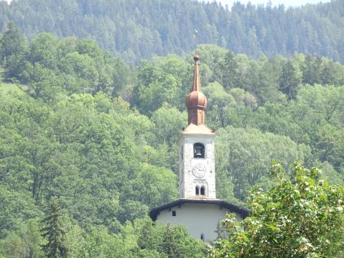 un bâtiment avec une tour d'horloge au milieu d'une forêt dans l'établissement Charmant studio à Landry, à Landry