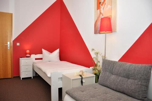 マイニンゲンにあるHotel An der Kapelleのベッドと椅子付きの小さな部屋です。