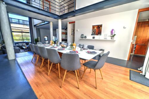 une salle à manger avec une longue table et des chaises dans l'établissement La Grange Emnitan - Maison de ville moderne pour 12p Fêtes interdites, à Saint-Genis-Pouilly