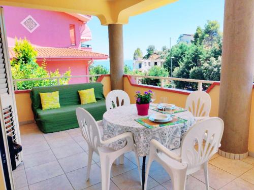 un tavolo e sedie su un balcone con divano di Villetta a Trebisacce con vista mare a Trebisacce