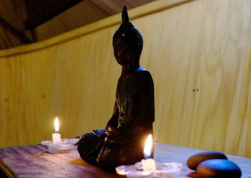 a statue of a person sitting on a table with candles at Lodge del Maipo in San José de Maipo