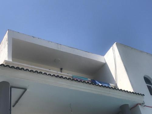 a white building with a ledge on top of it at Too Many Suites in Saïdia