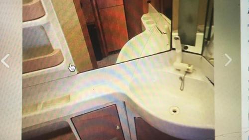 ein Bad mit einem Waschbecken und einem Spiegel in der Unterkunft Caravane à louer in Sennecey-le-Grand