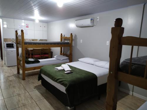 a room with two bunk beds and a kitchen at Pousada Do Galdino in Blumenau