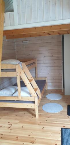 Etagenbett in einem Zimmer mit Holzwänden in der Unterkunft Lussebo 9 in Lidköping