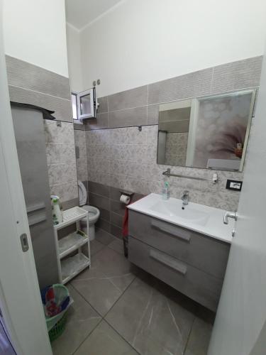 a bathroom with a sink and a mirror and a toilet at Casa del re in Licata