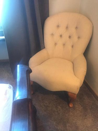 a white chair sitting in a room with a guitar at Number 10 Locanda B&B in Belvedere Langhe
