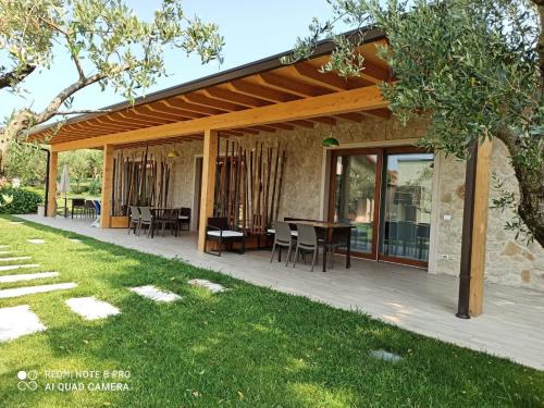 a pavilion with a table and chairs on a deck at Villa Maddalena in Bardolino