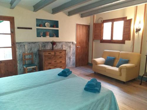 - une chambre avec un grand lit et un canapé dans l'établissement Casa Rural Marila, à Puigmoreno
