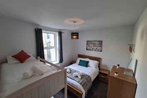 a bedroom with two beds and a window at Beautiful Seaside Apartment With Parking in Ventnor