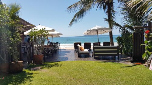a deck with chairs and umbrellas on the beach at Pousada Pedra da Gaivota in Bombinhas