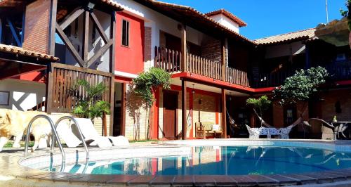 a swimming pool in front of a house at Pousada Holú in Itaúnas
