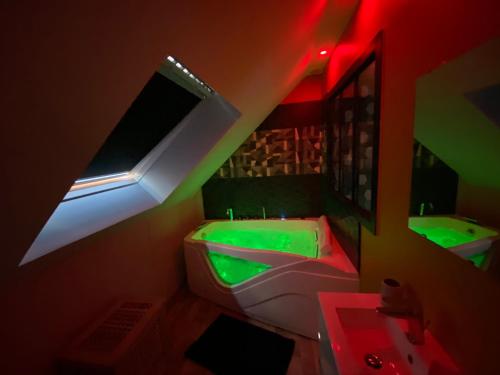 a bathroom with green and red lights and a sink at Logements équipés à Onnaing avec espace Balneo en OPTION proche Toyota, autoroute et Valenciennes in Onnaing