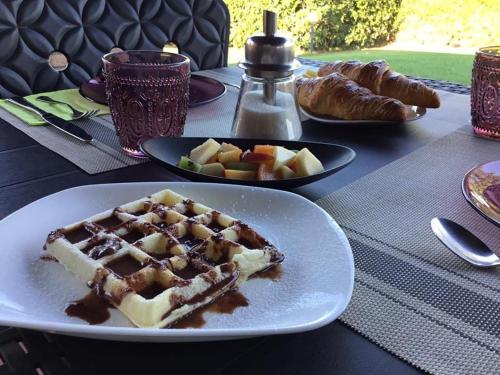 einen Teller Waffeln und Obst auf dem Tisch in der Unterkunft Le Siepi in Magliano in Toscana