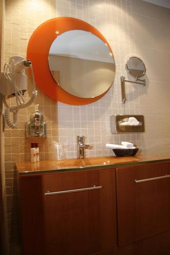 a bathroom with an orange mirror and a sink at Posada Los Gallos in Escalante