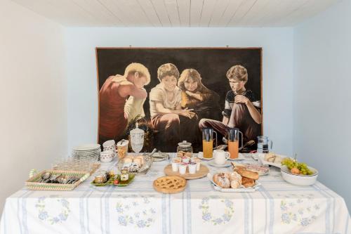 a table with food and a painting on the wall at Villa Caterina b&b in Procida