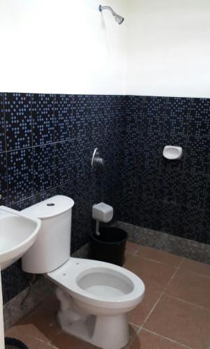 a bathroom with a white toilet and a sink at Rent! Monthly or More in San Juan