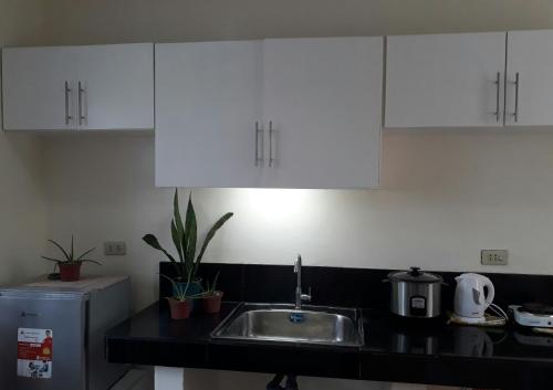 a kitchen with white cabinets and a sink at Rent! Monthly or More in San Juan
