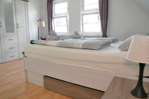 a bedroom with a large white bed with a window at Ferienwohnung Werenberg Goslar in Goslar