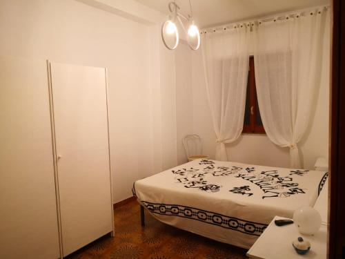 Habitación pequeña con cama y ventana en appartamento in villa a Pietragrande, en Stalettì
