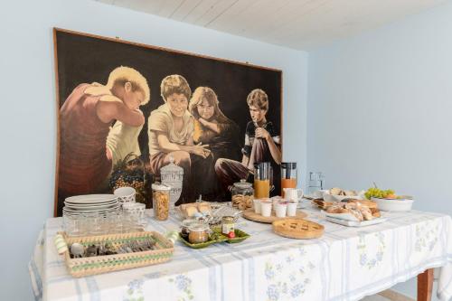 a table with food on it in front of a painting at Villa Caterina b&b in Procida