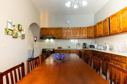 a kitchen with a large wooden table with flowers on it at Casa do Pescador SBMP-1 in Faial da Terra