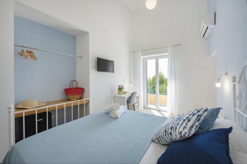 a bedroom with a blue bed and a window at Villa Caterina b&b in Procida